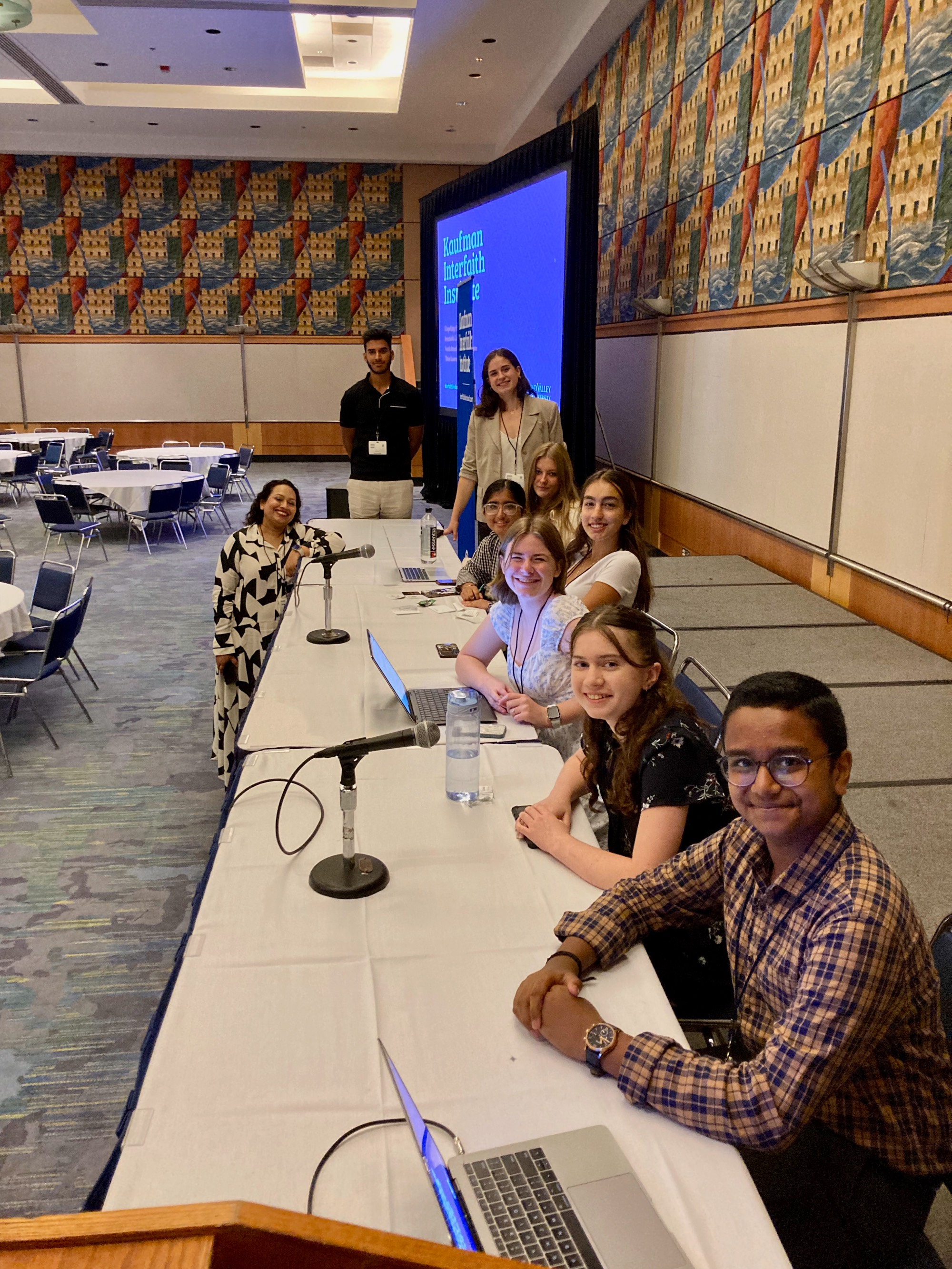 Eight students at a presentation with their teacher